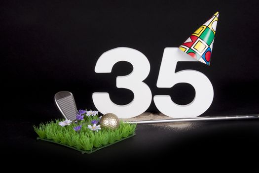 A golf club and golf ball on an artificial peace of grass to be used as a birthday card