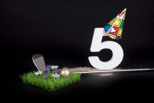 A golf club and golf ball on an artificial peace of grass to be used as a birthday card