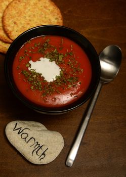 tomato soup for warmth on a wooden background with crackers