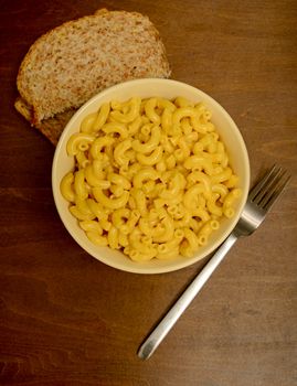 macaroni and cheese with whole grain bread on wood background