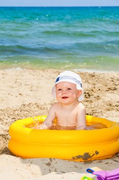 Happy baby boy playing on a beach