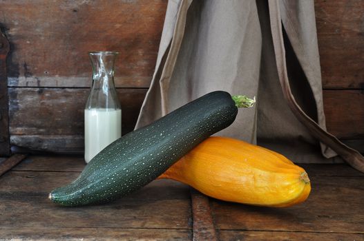 Squash on old wooden bench with milk bottle and apron vintage style.