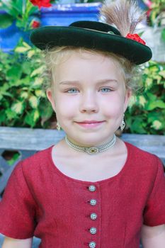 Portrait of a little girl with hat in traditional Bavarian dirndl