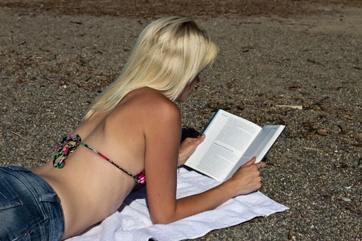 Woman reading a book on the beach