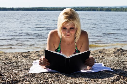 Woman reading a book on the beach