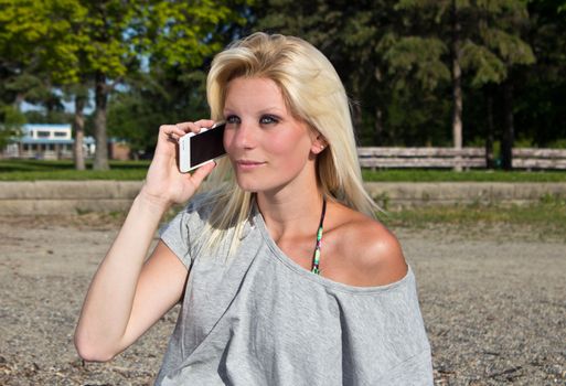 Young woman talking on smart phone on the beach