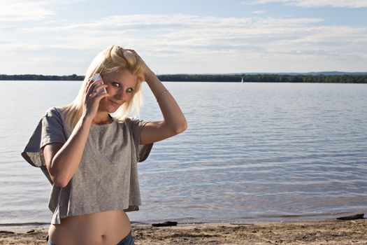 Young woman talking on smart phone on the beach