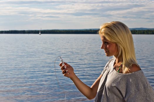 Young woman on the beach listening to music