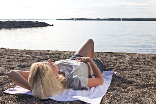 Young woman on the beach listening to music