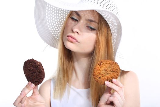 Cute young woman eats cookies on the white background