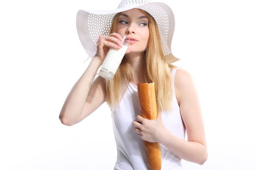 Portrait of woman holding a baguette and drinking from a glass of milk