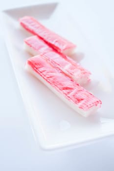 Crab sticks group on white plate, stock photo