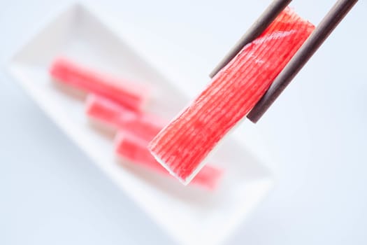 Set of crab sticks with chopsticks on white background, stock photo