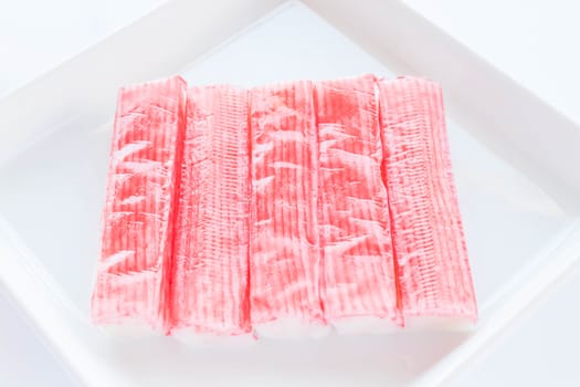 Group of crab sticks  on white plate, stock photo