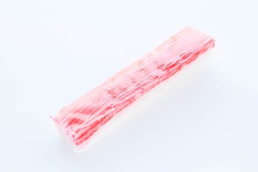 Piece of crab stick isolated on white background, stock photo