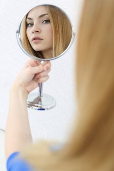 Girl looks in the mirror