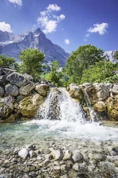 Picture of a waterfall and rocks in the Austrian Alps with trees and mountains