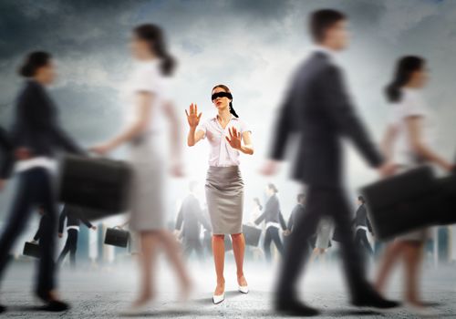 Image of businesswoman in blindfold walking among group of people