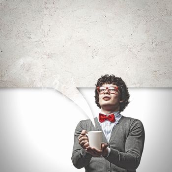 Young man with blank frames against a grey wall