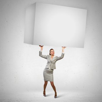 Image of business woman holding heavy white cube above head