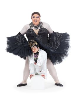 Two drag queens performing together in humorous caricature of women, on white