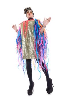 Fashion conscious drag queen in a glitzy gold dress, high heeled stilettos and with streamers performing in a show, isolated on white