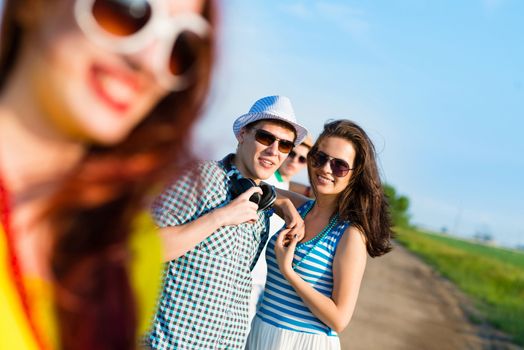 young couple standing on the road, having fun with friends