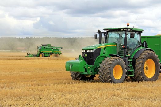 SALO, FINLAND - AUGUST 10: John Deere 7280R Agricultural Tractor and Modern Combine Harvester T560 displayed at the annual Puontin Peltopaivat Agricultural Show in Salo, Finland on August 10, 2013.