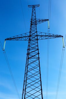 Support of a line of high-voltage electricity transmissions on a background of the blue sky