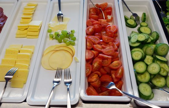 vegetables and cheese on the trays in the restaurant