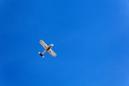 Small flying aircraft in a blue sky