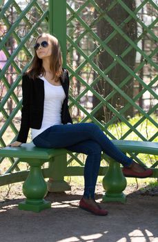 Woman in Fashionable Outfit Sitting on Outdoor Bench
