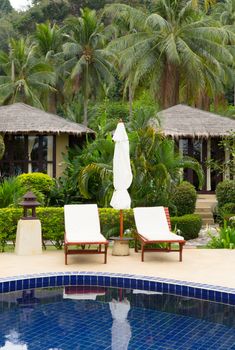 Bungalows and a swimming pool in tropical hotel