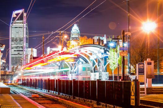 Charlotte City Skyline night scene with light rail system lynx train