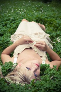 Summer. Portrait of  blonde girl having rest at clover meadow