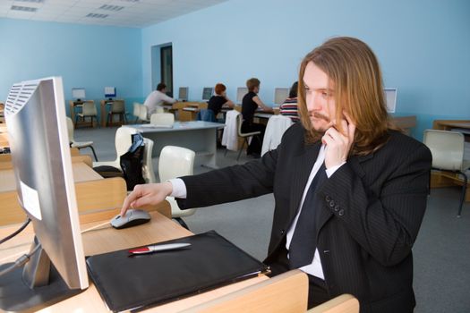 Young businessman is talking by mobile phone & also receives the information by computer.