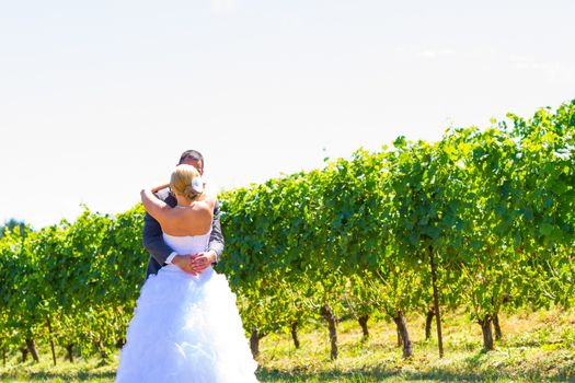 A man and woman share a first look moment as bride and groom outdoors at a winery vineyard in Oregon.