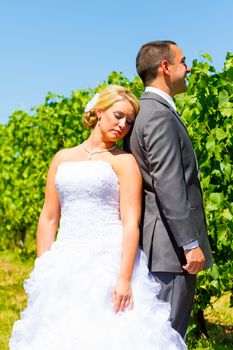 A bride and groom pose for portraits on their wedding day at a winery vineyard outdoors in oregon.