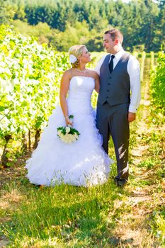 Portraits of a bride and groom outdoors in a vineyard at a winery in Oregon right after their ceremony and vows.