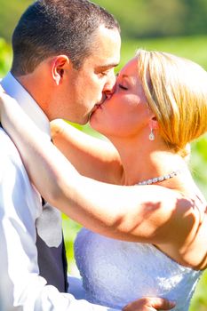 A bride and groom share a kiss after their ceremony on their wedding day at a vineyard winery in Oregon outdoors.