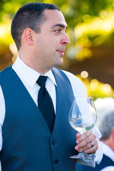 A groom reacts and enjoys the moment during the best man and maid of honor toasts at his wedding.