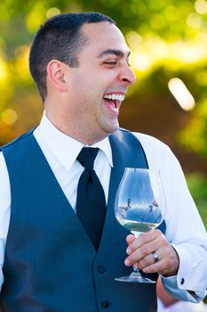 A groom reacts and enjoys the moment during the best man and maid of honor toasts at his wedding.