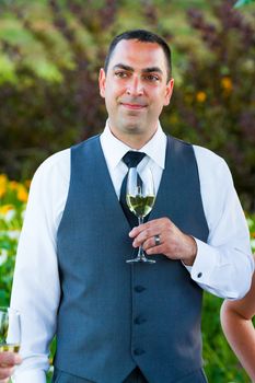 A groom reacts and enjoys the moment during the best man and maid of honor toasts at his wedding.