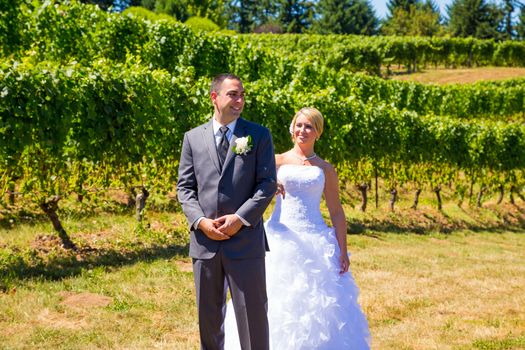 A man and woman share a first look moment as bride and groom outdoors at a winery vineyard in Oregon.