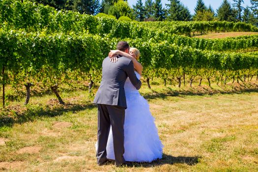A man and woman share a first look moment as bride and groom outdoors at a winery vineyard in Oregon.