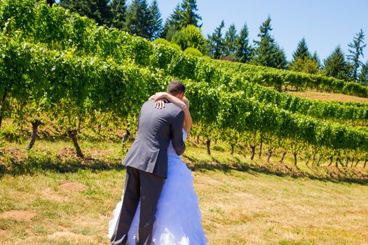 A man and woman share a first look moment as bride and groom outdoors at a winery vineyard in Oregon.