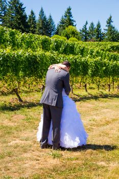 A man and woman share a first look moment as bride and groom outdoors at a winery vineyard in Oregon.