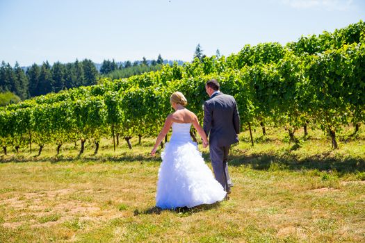 A man and woman share a first look moment as bride and groom outdoors at a winery vineyard in Oregon.