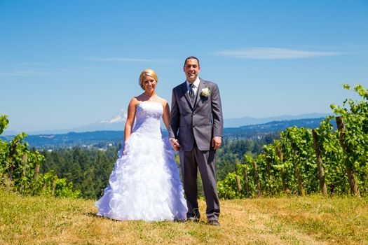 A bride and groom pose for portraits on their wedding day at a winery vineyard outdoors in oregon.