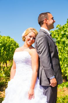 A bride and groom pose for portraits on their wedding day at a winery vineyard outdoors in oregon.